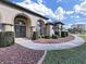Stately home entrance, featuring an elegant front door, archways, and manicured landscaping at 11213 Warm Wind Way, Weeki Wachee, FL 34613