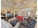 Comfortable living area featuring fireplace, couches, access to kitchen, and coffered ceiling at 11213 Warm Wind Way, Weeki Wachee, FL 34613