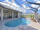 Screened-in pool area features a kidney-shaped pool, spa and paved patio area at 11213 Warm Wind Way, Weeki Wachee, FL 34613