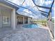 Covered outdoor living space next to a screened-in pool and spa with paver patio at 11213 Warm Wind Way, Weeki Wachee, FL 34613