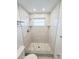 Walk-in shower with tiled walls, a shower head, a window, and stone floors at 6075 Shore S Blvd # 306, Gulfport, FL 33707