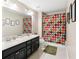 Bathroom boasts double vanity, colorful shower curtain, and decorative touches at 11544 Lake Lucaya Dr, Riverview, FL 33579