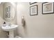 Powder room with pedestal sink, round mirror, and decorative wall art at 11544 Lake Lucaya Dr, Riverview, FL 33579