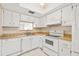 Clean condo kitchen featuring white cabinets and appliances at 2465 Northside Dr # 205, Clearwater, FL 33761