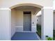 Inviting front door entrance with arched entryway and gray door at 8333 Hardy Bay Loop, Wesley Chapel, FL 33545