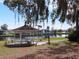 White gazebo with picnic table overlooking a lake, surrounded by lush landscaping at 35127 Danny Dr, Zephyrhills, FL 33541