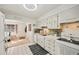 Bright kitchen features white cabinets, stainless steel sink, and view into adjacent living area at 11200 102Nd N Ave # 66, Seminole, FL 33778