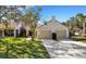 Two-car garage villa with red tile roof and landscaped yard at 1120 Tartan Dr, Palm Harbor, FL 34684