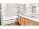 Bathroom with double vanity, large soaking tub, and wood cabinets at 4043 Fox Ridge Blvd, Wesley Chapel, FL 33543