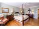 Spacious bedroom with hardwood floors, a four-poster bed, and an armchair at 4202 W Culbreath Ave, Tampa, FL 33609