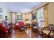 Living room with hardwood floors, red sofa, and floral window treatments at 4202 W Culbreath Ave, Tampa, FL 33609