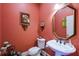 Stylish powder room with a pedestal sink, updated fixtures, and coral walls at 4202 W Culbreath Ave, Tampa, FL 33609