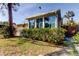 Backyard view showing a sunroom addition and lush landscaping at 1747 Douglas Ave, Dunedin, FL 34698