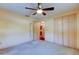 Spacious bedroom with ceiling fan and mirrored closet doors at 1747 Douglas Ave, Dunedin, FL 34698