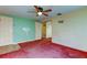 Living area with red carpet, ceiling fan and access to other rooms at 1747 Douglas Ave, Dunedin, FL 34698