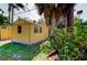 Bright yellow storage shed in the backyard, providing ample storage space at 1747 Douglas Ave, Dunedin, FL 34698