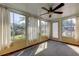 Bright sunroom featuring multiple windows and a ceiling fan at 1747 Douglas Ave, Dunedin, FL 34698