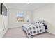 Bright bedroom with a comfy bed, wall-mounted TV, and window with blinds at 33055 Tulip Petal Ln, Wesley Chapel, FL 33545