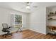 Home office or bedroom with hardwood floors, large window, and built-in shelving at 3722 Village Estates Pl, Tampa, FL 33618