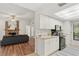 Bright kitchen features white cabinets, black appliances, and a view into the living room at 3722 Village Estates Pl, Tampa, FL 33618