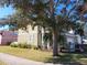 Two-story house with a gray facade, landscaping, and large tree in front at 6519 Simone Shores Cir, Apollo Beach, FL 33572