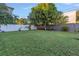 Large grassy backyard with mature trees and a white fence at 323 30Th N Ave, St Petersburg, FL 33704