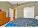 Spacious bedroom with a plaid comforter and double door closet at 11220 Paradise Point Way, New Port Richey, FL 34654