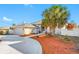 Side view of a single-story home with a circular driveway and mature palm trees at 2801 Gulf Blvd, Belleair Beach, FL 33786