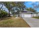 Gray house with white garage door, landscaping, and a walkway at 3117 S Canal Dr, Palm Harbor, FL 34684