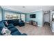 Living room with a sectional sofa, wood-look tile floors, and a large TV at 4051 30Th N Ave, St Petersburg, FL 33713
