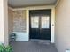 Charming entrance with double front doors, complemented by a stone accent wall and inviting brick walkway at 1105 Savannah Landings Ave, Valrico, FL 33596