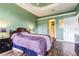 A cozy bedroom features a comfortable bed, dark wood floors, and soothing green walls at 1105 Savannah Landings Ave, Valrico, FL 33596