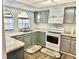 L-shaped kitchen with gray cabinets and white appliances at 9107 Lingrove Rd, Weeki Wachee, FL 34613