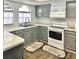 L-shaped kitchen with gray cabinets and white appliances at 9107 Lingrove Rd, Weeki Wachee, FL 34613