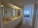 Bright bathroom with double vanity, large mirror, and access to the bedroom with water view at 1540 Gulf Blvd # 2107, Clearwater Beach, FL 33767