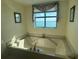 Relaxing bathroom featuring a large soaking tub and a scenic window view at 1540 Gulf Blvd # 2107, Clearwater Beach, FL 33767