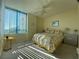 Bright bedroom featuring a large window with blinds, ceiling fan, and coordinated bedding at 1540 Gulf Blvd # 2107, Clearwater Beach, FL 33767