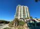 Exterior shot of a tall ocean-view condo building, landscaped with palm trees at 1540 Gulf Blvd # 2107, Clearwater Beach, FL 33767