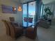 Dining area features a glass table with seating for six, chandelier, and access to balcony with ocean view at 1540 Gulf Blvd # 2107, Clearwater Beach, FL 33767