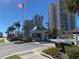 The beachfront condo complex welcomes with a charming guardhouse, lush landscaping and the American flag at 1540 Gulf Blvd # 2107, Clearwater Beach, FL 33767