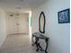 Hallway leading to front door with tile floors, decorative table, and wall decor at 1540 Gulf Blvd # 2107, Clearwater Beach, FL 33767