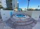 Outdoor round hot tub with brick trim, stairs, and a metal handrail at 1540 Gulf Blvd # 2107, Clearwater Beach, FL 33767