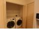 Well-lit laundry room with washer, dryer, and shelving at 19409 Weymouth Dr, Land O Lakes, FL 34638