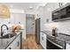 Modern kitchen with white cabinets, stainless steel appliances, and gray countertops at 3463 Timber Crossing Ave, Brandon, FL 33511