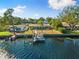 Aerial view showcasing waterfront property, private dock, and boat at 152 Carlyle Dr, Palm Harbor, FL 34683