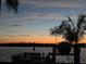 Peaceful sunset view over the water with palm trees and a boat at 152 Carlyle Dr, Palm Harbor, FL 34683