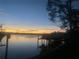 Beautiful sunset view over calm water with a dock and boat at 152 Carlyle Dr, Palm Harbor, FL 34683