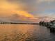 Gorgeous sunset view over calm water with a dock and boats at 152 Carlyle Dr, Palm Harbor, FL 34683