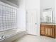 Primary bathroom with granite vanity, soaking tub, and glass block window at 18518 Avocet Dr, Lutz, FL 33558