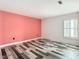 Bedroom with coral accent wall, wood-look floors, and updated window at 18518 Avocet Dr, Lutz, FL 33558